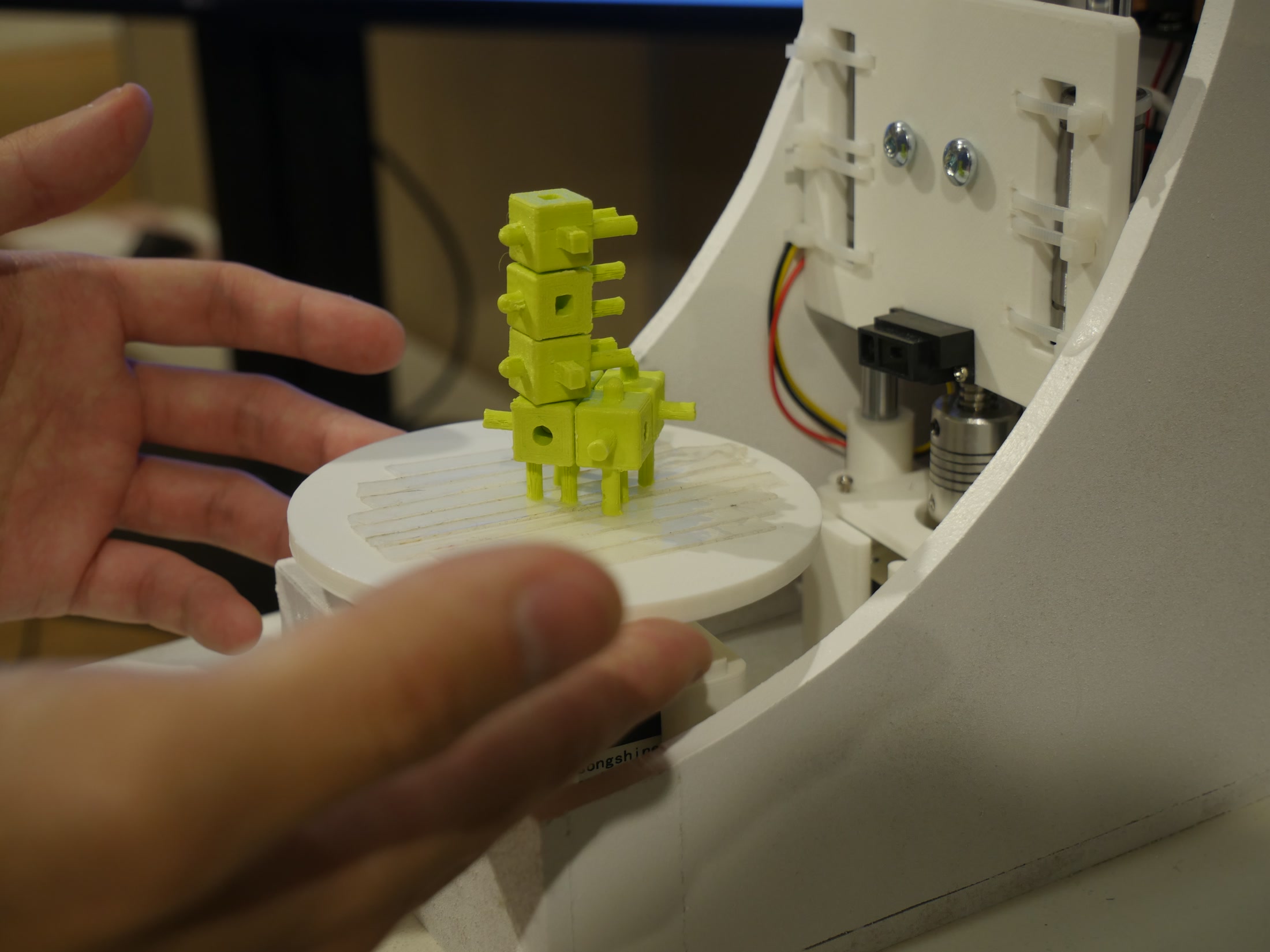 Hands placing an assembled green form on the scanner turntable