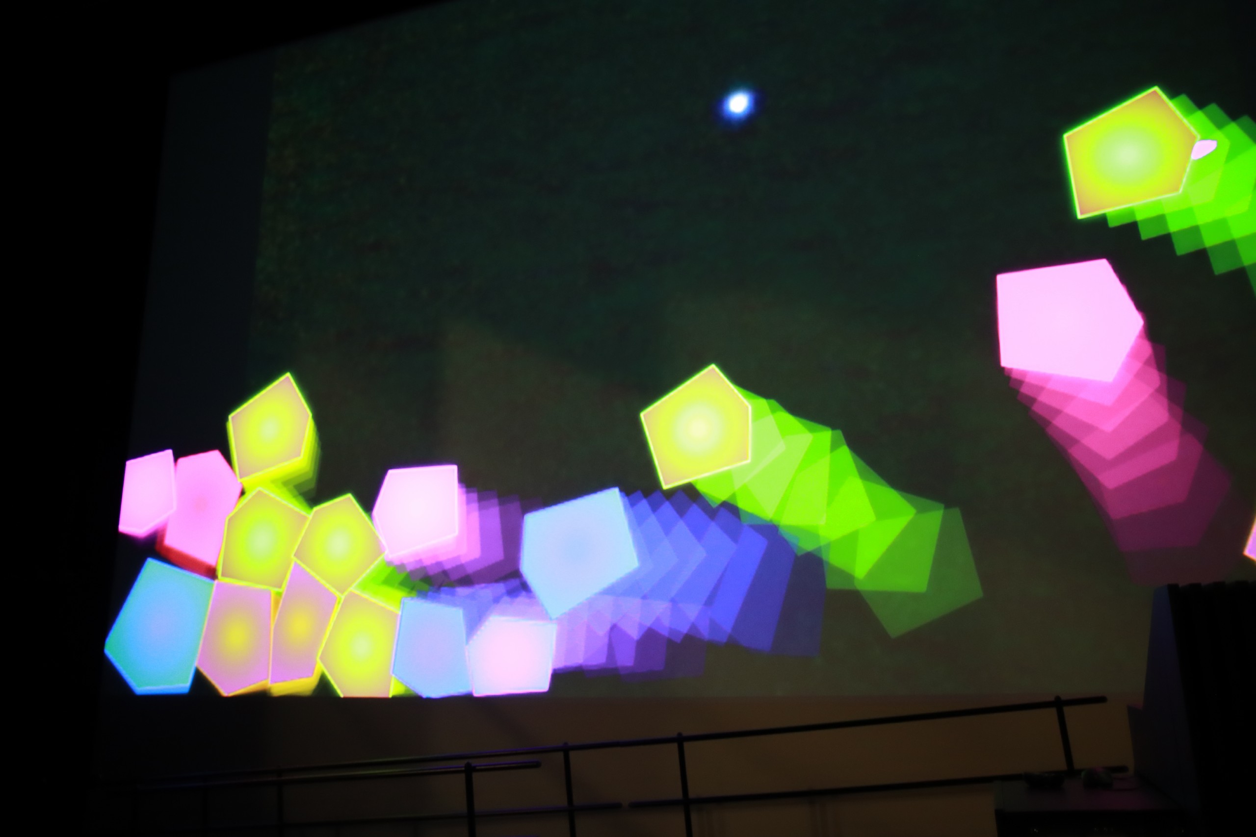Colourful digital blobs accumulating and moving across the projection